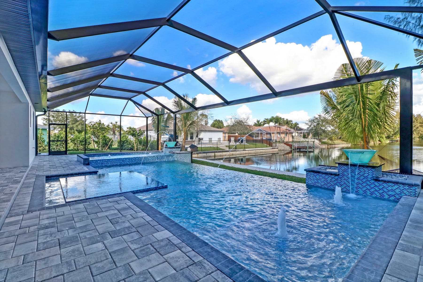 Screened pool and outdoor living area overlooking a canal.