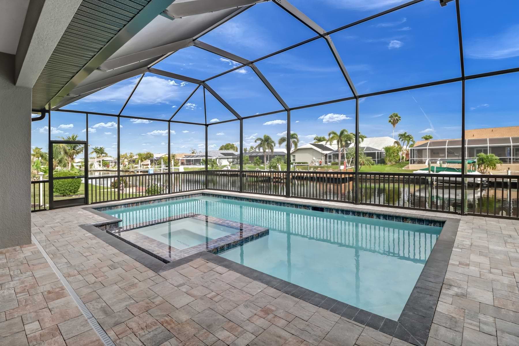 Screened pool and spa overlooking the canal in a completed Bonita Springs home.