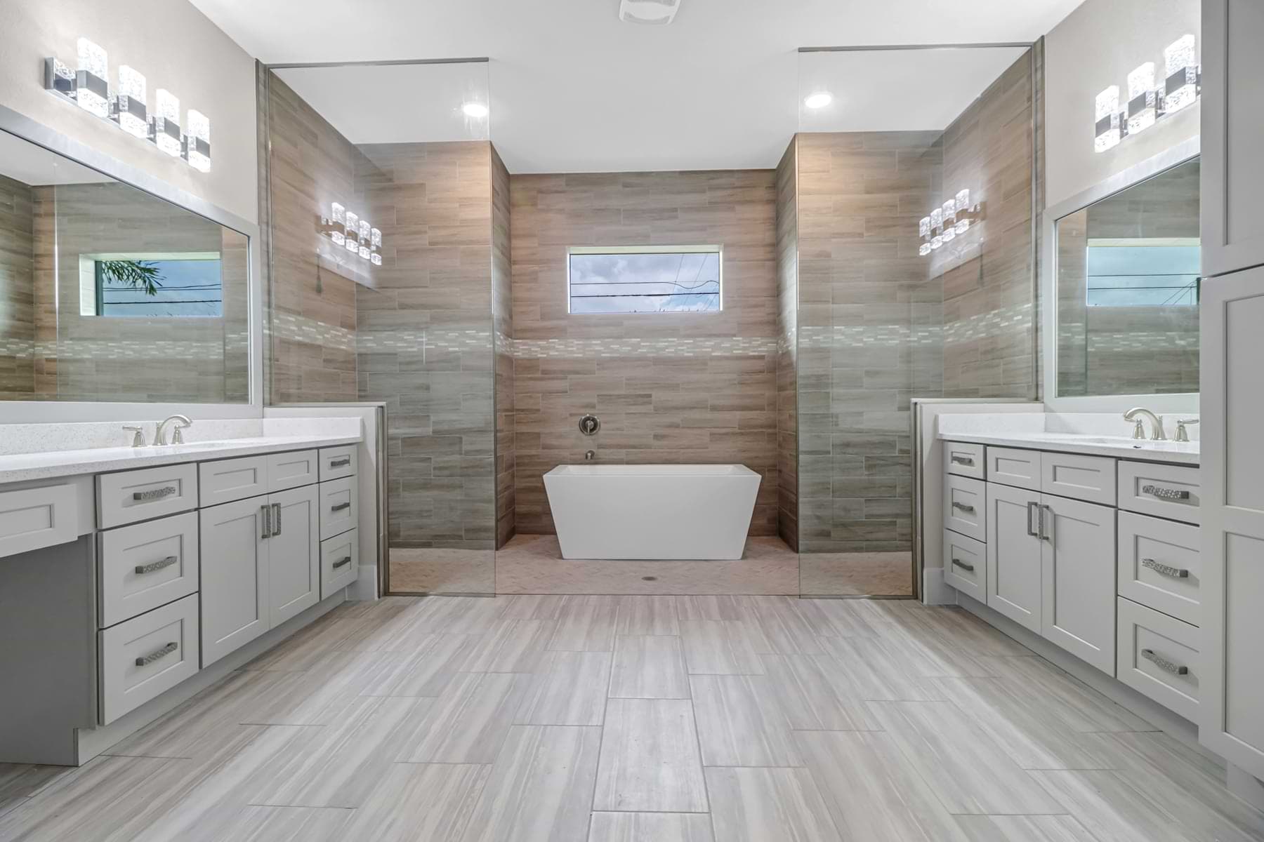 Primary bathroom with dual vanities and freestanding tub in a completed Estero home.