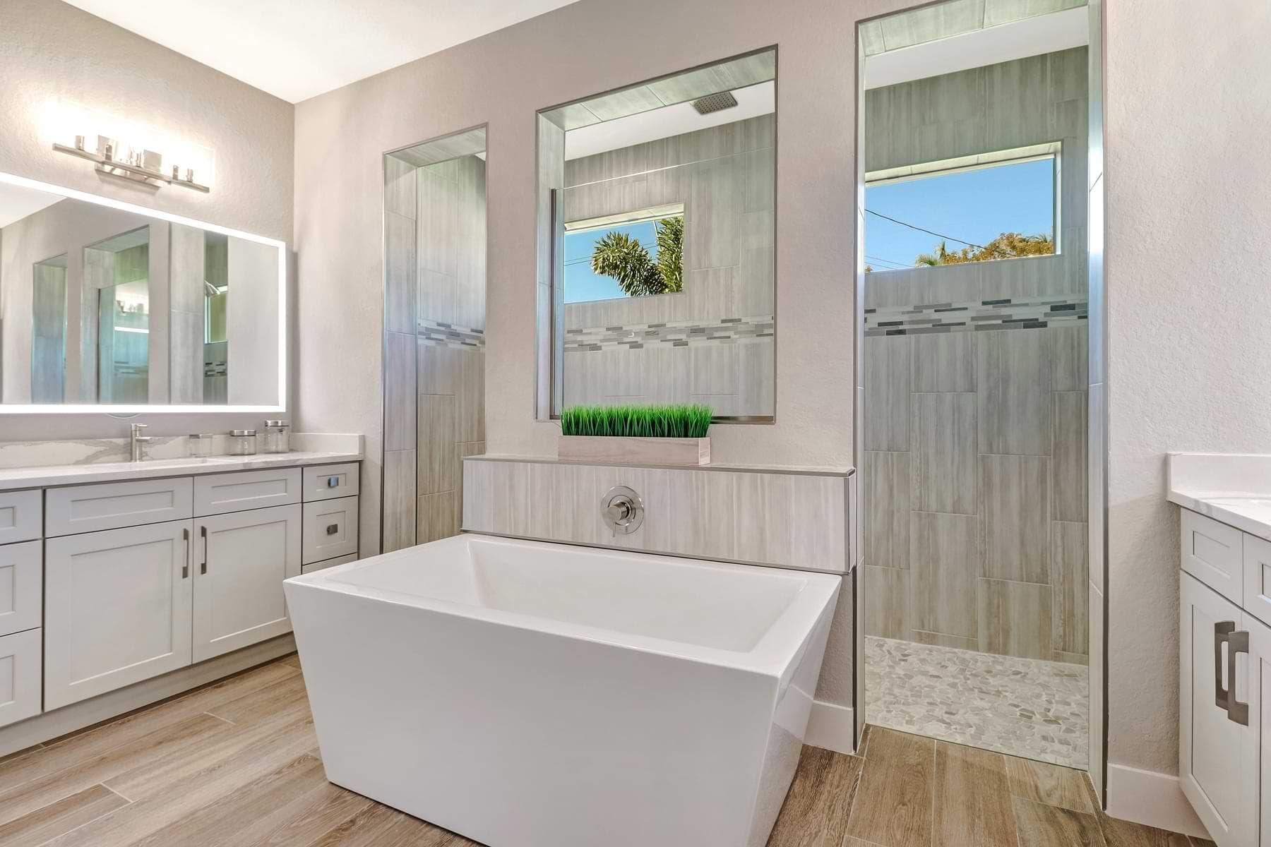 Primary bathroom with freestanding tub and walk-in shower in a completed Fort Denaud home.