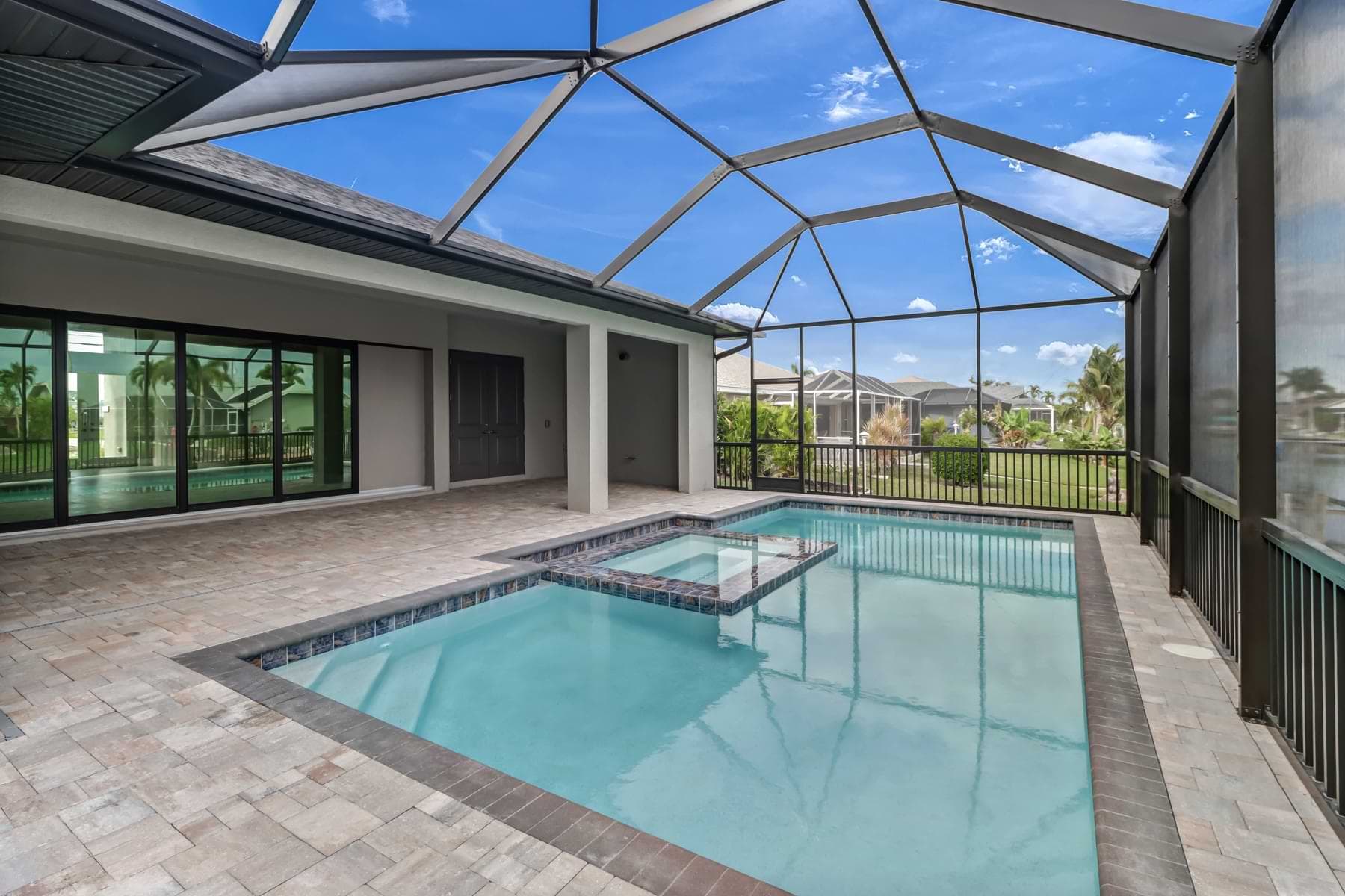 Screened pool and spa off the covered lanai in a completed North Naples home.