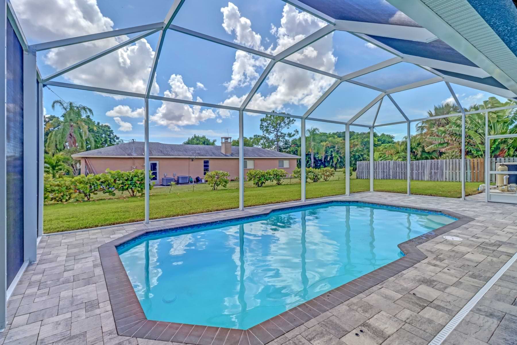 Screened Haven pool with angled corners and a paver deck overlooking the backyard