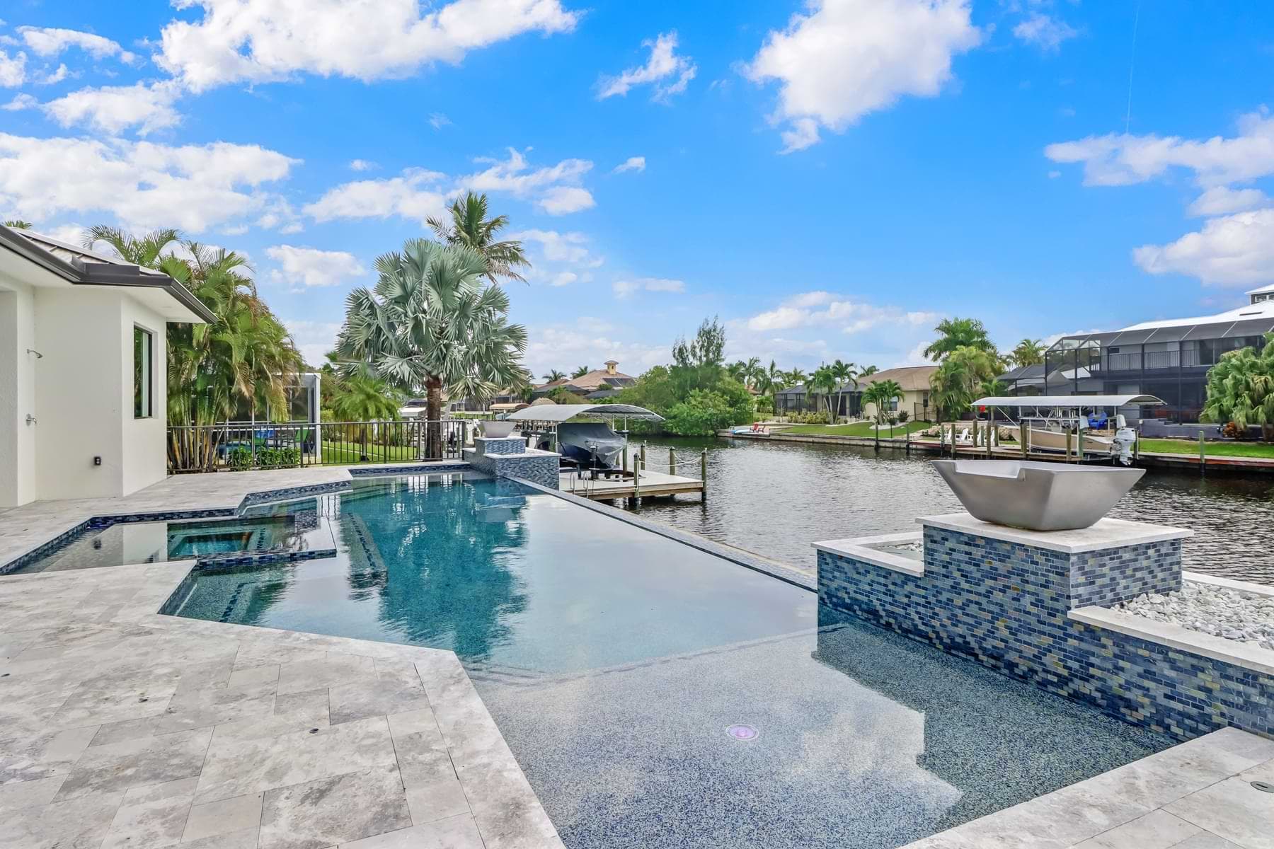 Vista Grande pool with sun shelf, blue mosaic tile wall, and water bowl overlooking a canal