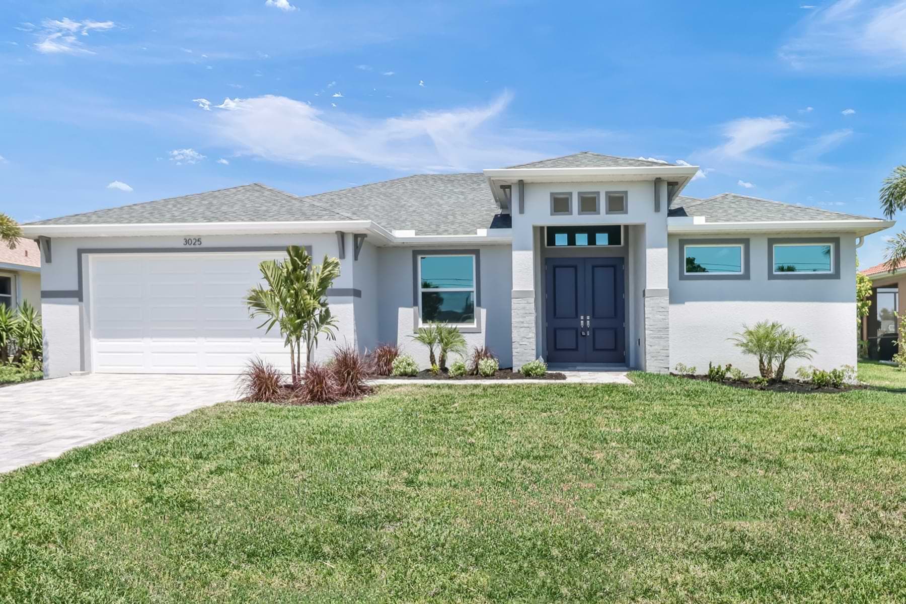 Front elevation of the Signus model home with landscaped yard and double entry doors.
