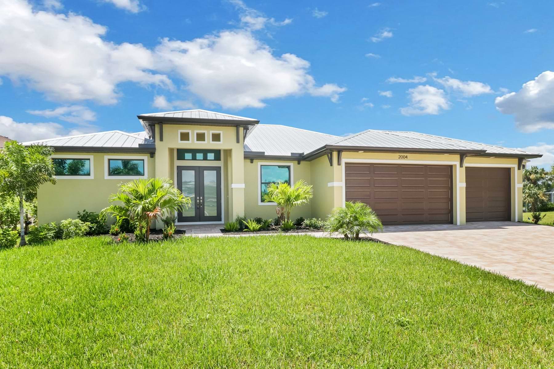 Front exterior of the Signus model home featuring a modern entry and three-car garage.