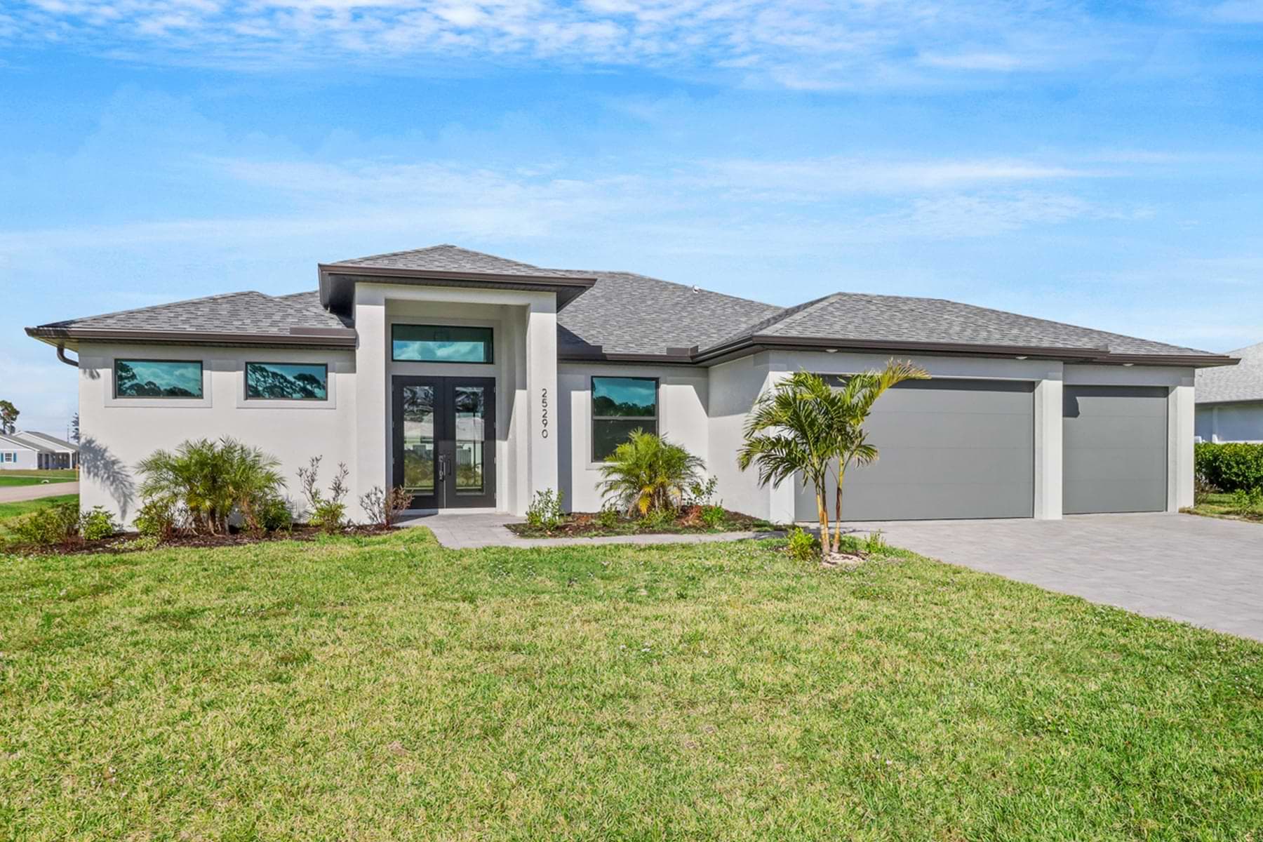 Front exterior of the Signus model home with modern lines, double glass entry, and three‑car garage