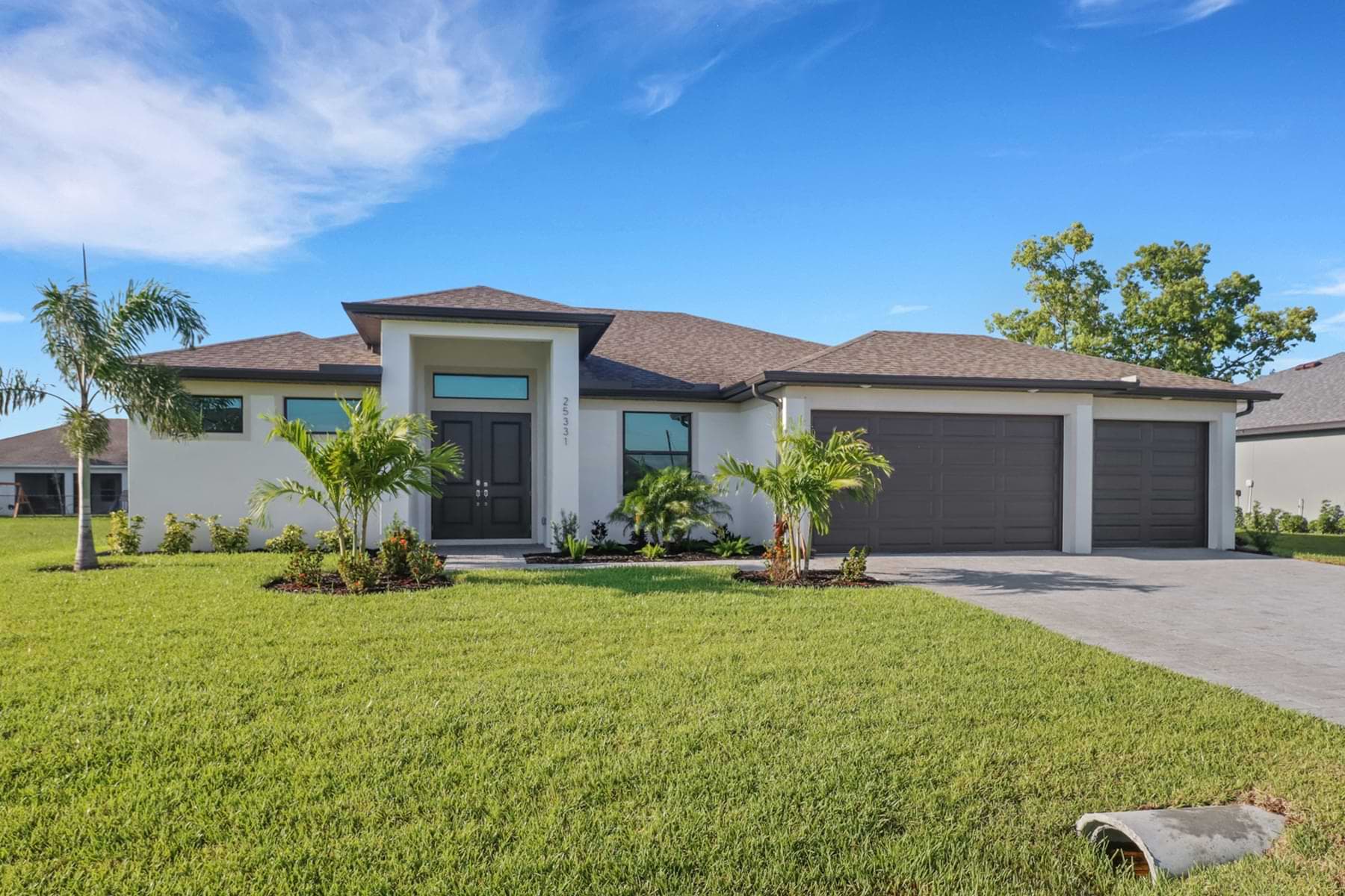 Front exterior of the Signus model home with 3-car garage and modern landscaping