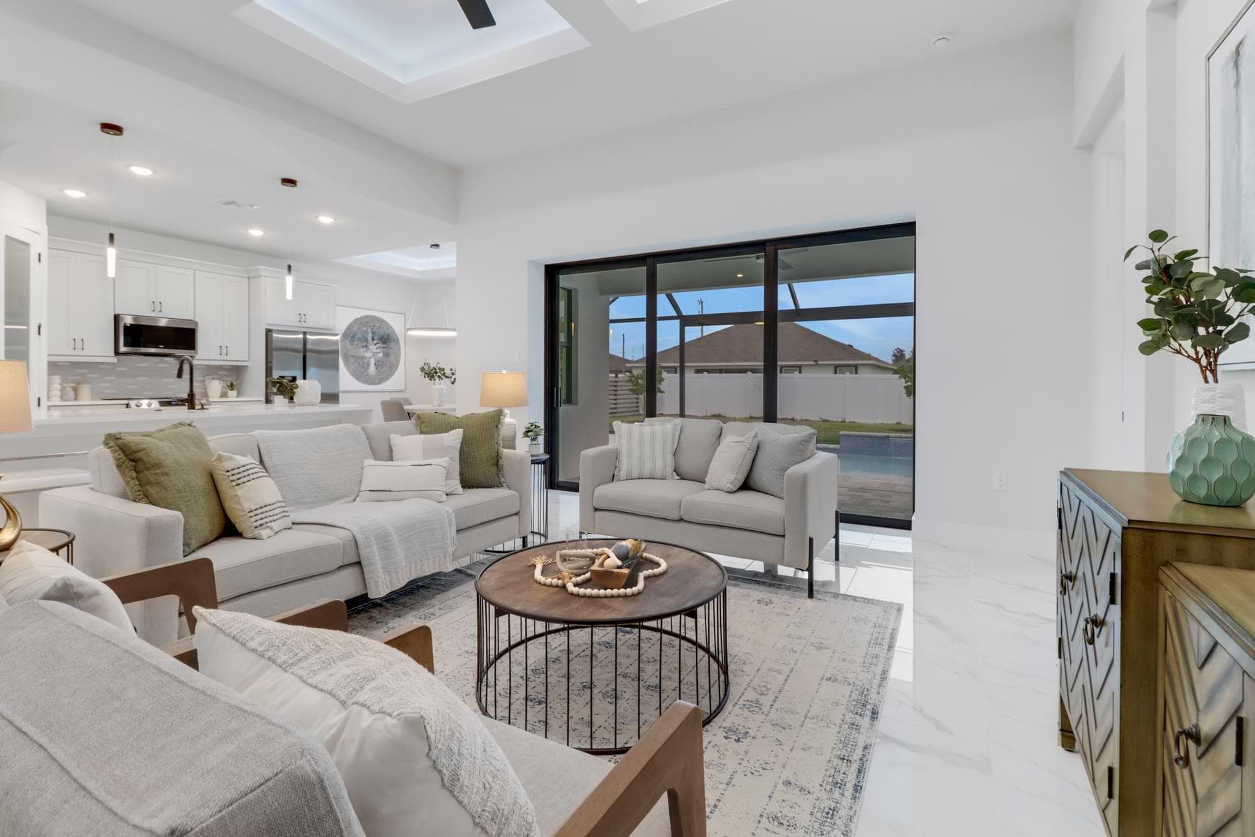 Furnished living room interior with sliding glass doors to the lanai in a completed Sposen Hardwyn home