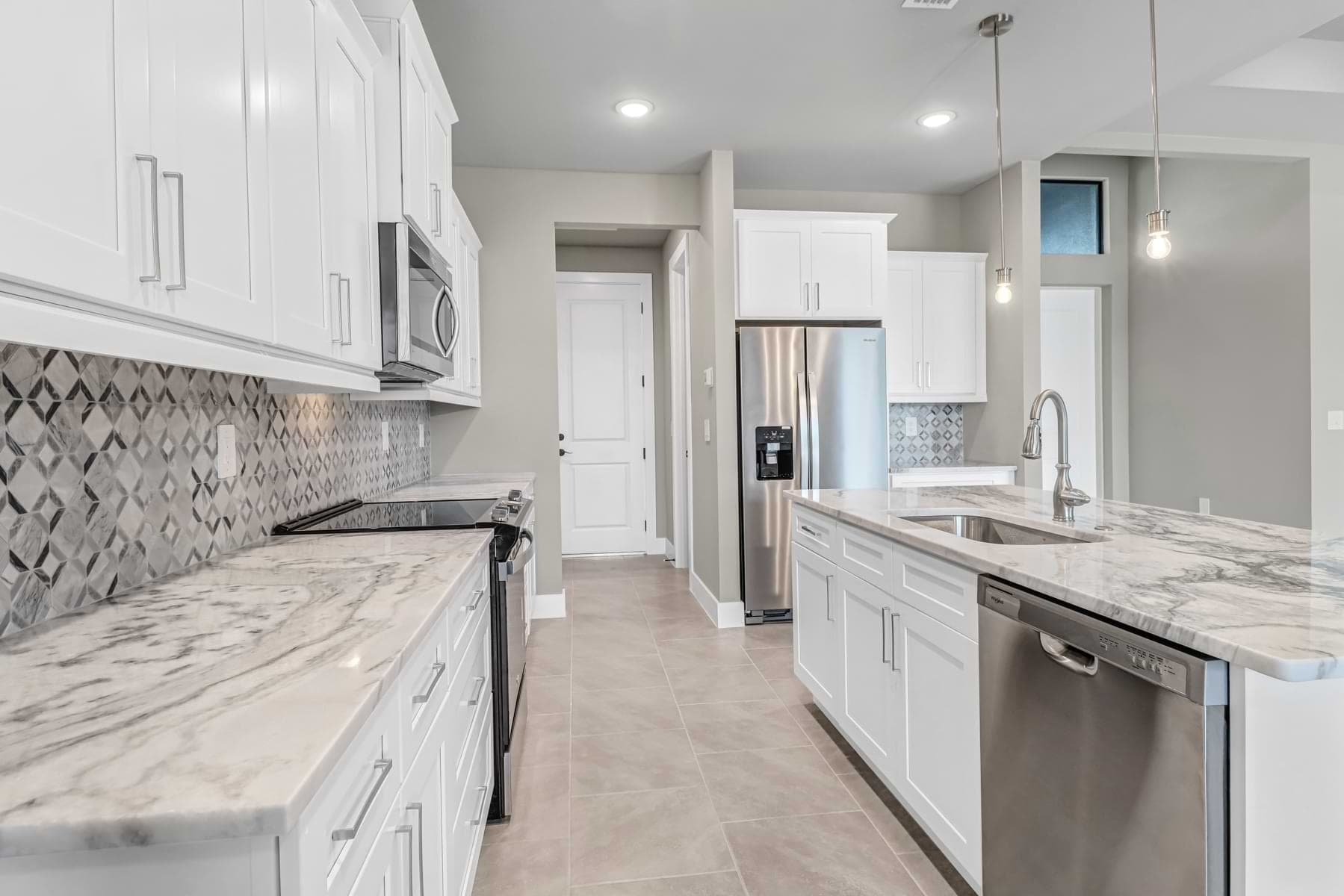 Kitchen with stone countertops and stainless appliances in a completed Buckingham home.