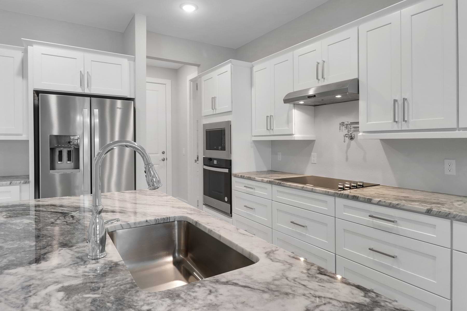 Kitchen with marble-look countertops and stainless appliances in a completed Port Charlotte home.